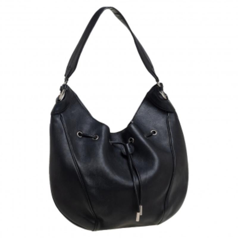 This hobo from Salvatore Ferragamo is crafted from leather in a black hue. It has a drawstring closure that opens to a canvas-lined interior. Feminine in design, the bag is perfect for everyday use.