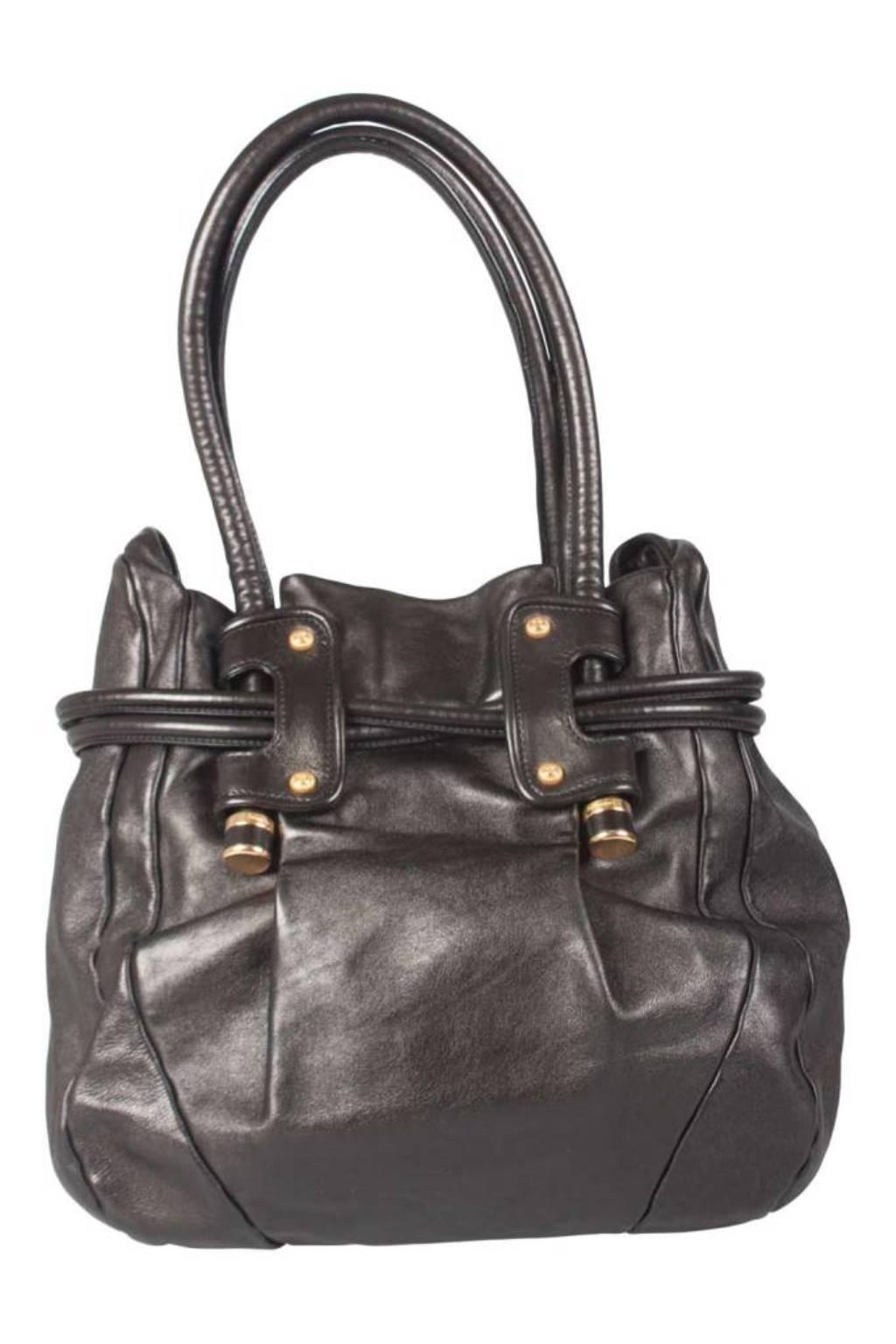 This Salvatore Ferragamo hobo is built for everyday use. Crafted from black leather, it has two handles for you to parade it. The nylon interior is secured by a snap button and a drawstring detail is added to enhance the design of the bag.

