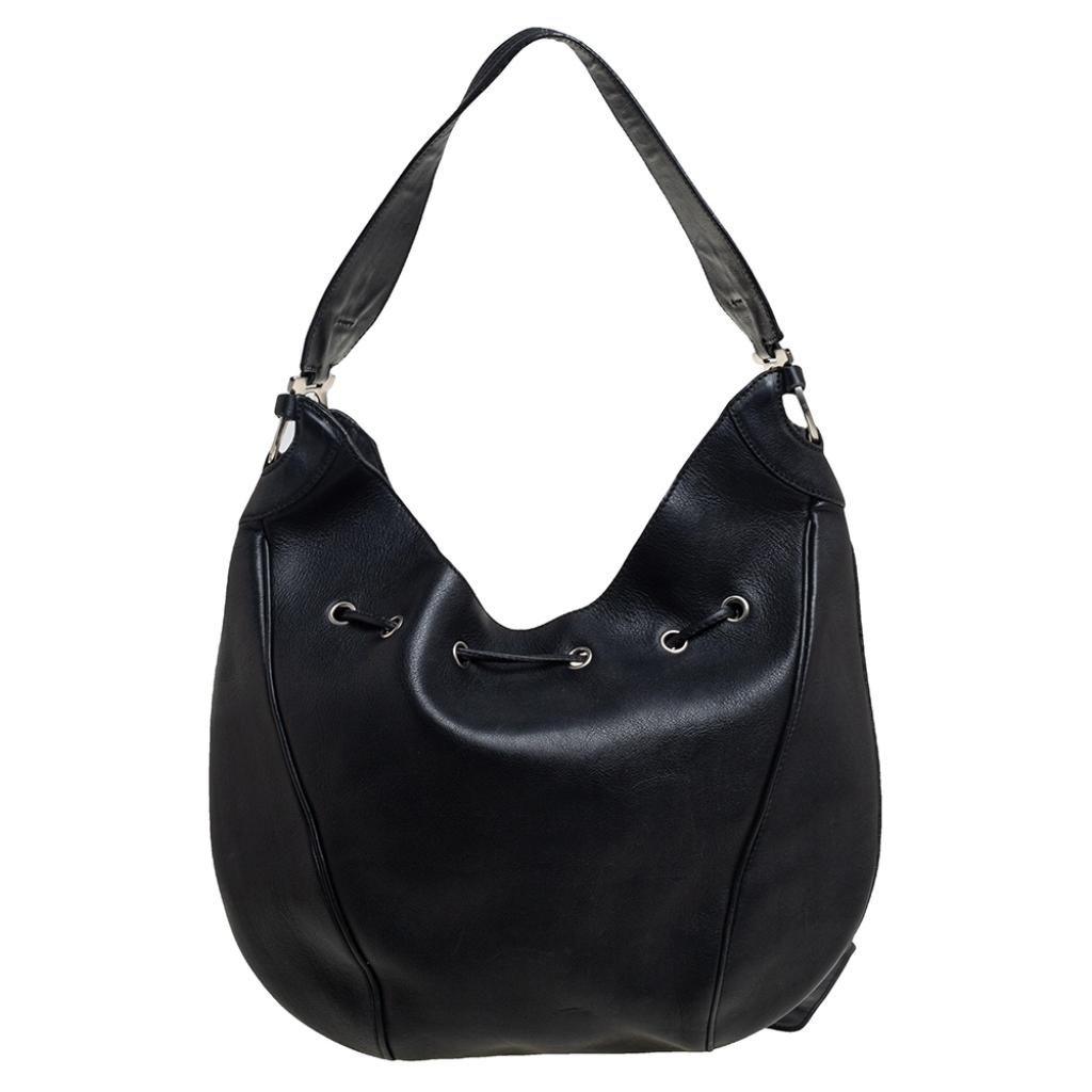This hobo from Salvatore Ferragamo is crafted from leather in a black hue. It has a drawstring closure that opens to a canvas-lined interior. Feminine in design, the bag is perfect for everyday use.

