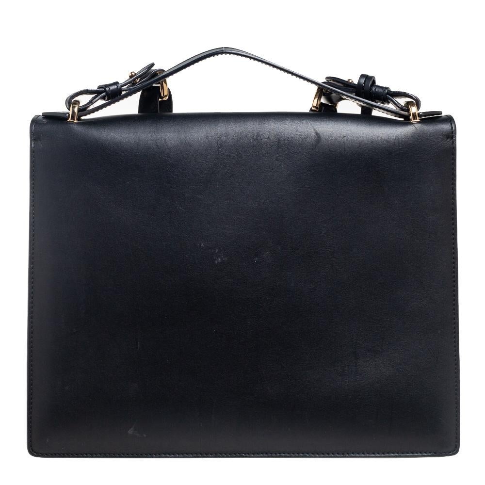 Simply sophisticated, this bag from the House of Salvatore Ferragamo makes a signature statement. The exterior of this bag is crafted using black leather with a gold-toned Gancio lock closure added to the front. It features a top handle and a