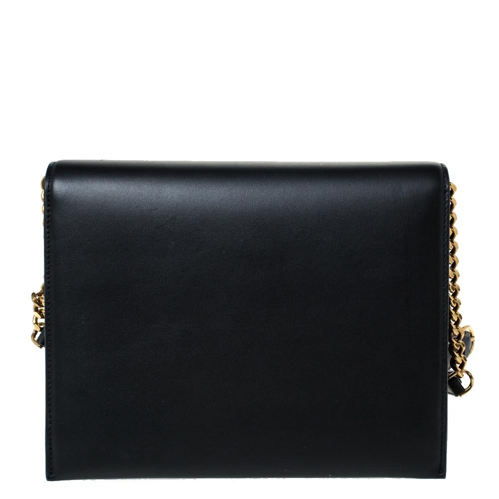 This structural shoulder bag comes from the house of Salvatore Ferragamo and is made in Italy. It is crafted from leather in a black hue and features a shoulder strap. The front flap is secured by a gold-tone Gancio lock which is a signature of the