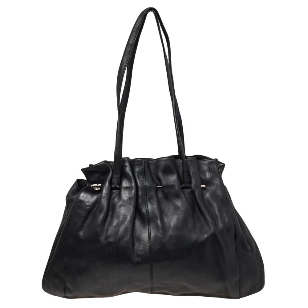 This bag from Salvatore Ferragamo is artistically designed to resonate with your sensation and to stay in tune with current trends. It flaunts a gathered pattern on the black leather exterior with the use of silver-toned accents. This functional,