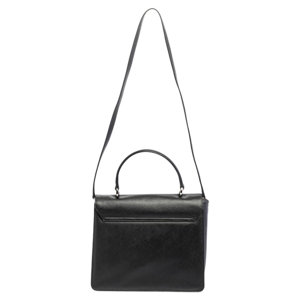 Bags from Salvatore Ferragamo are symbols of excellent craftsmanship and timeless design. This black Katia bag has been crafted from leather and styled with a front flap flaunting the signature Gancini buckle. It exhibits a single top handle and a