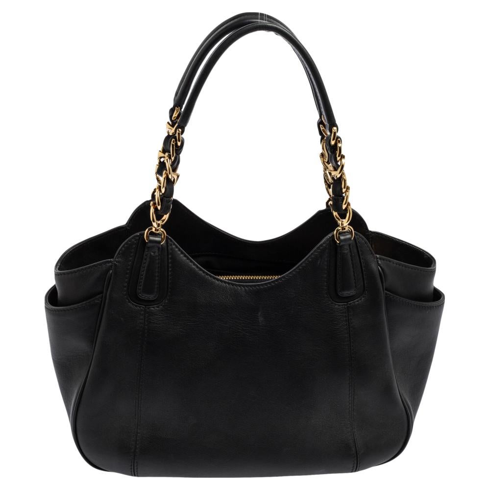 Salvatore Ferragamo’s Melinda tote is elegantly crafted from black leather without compromising on style. Besides a main roomy fabric-lined interior, it also has pockets on the sides of the exterior. It is finished with the brand logo at the front