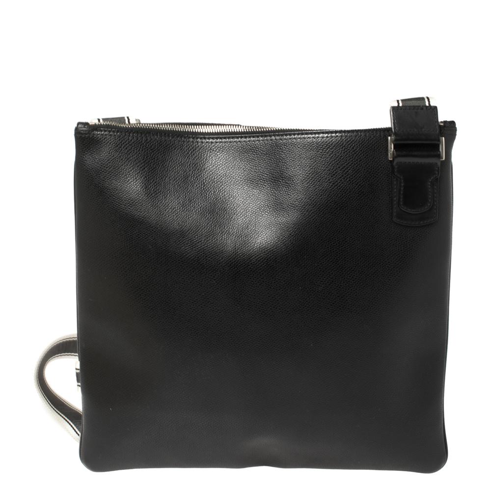 This Salvatore Ferragamo creation is crafted from durable black leather and lined with fine canvas. This messenger bag with a neatly designed exterior features slip pockets on the front and has enough space for your documents, wallet and other