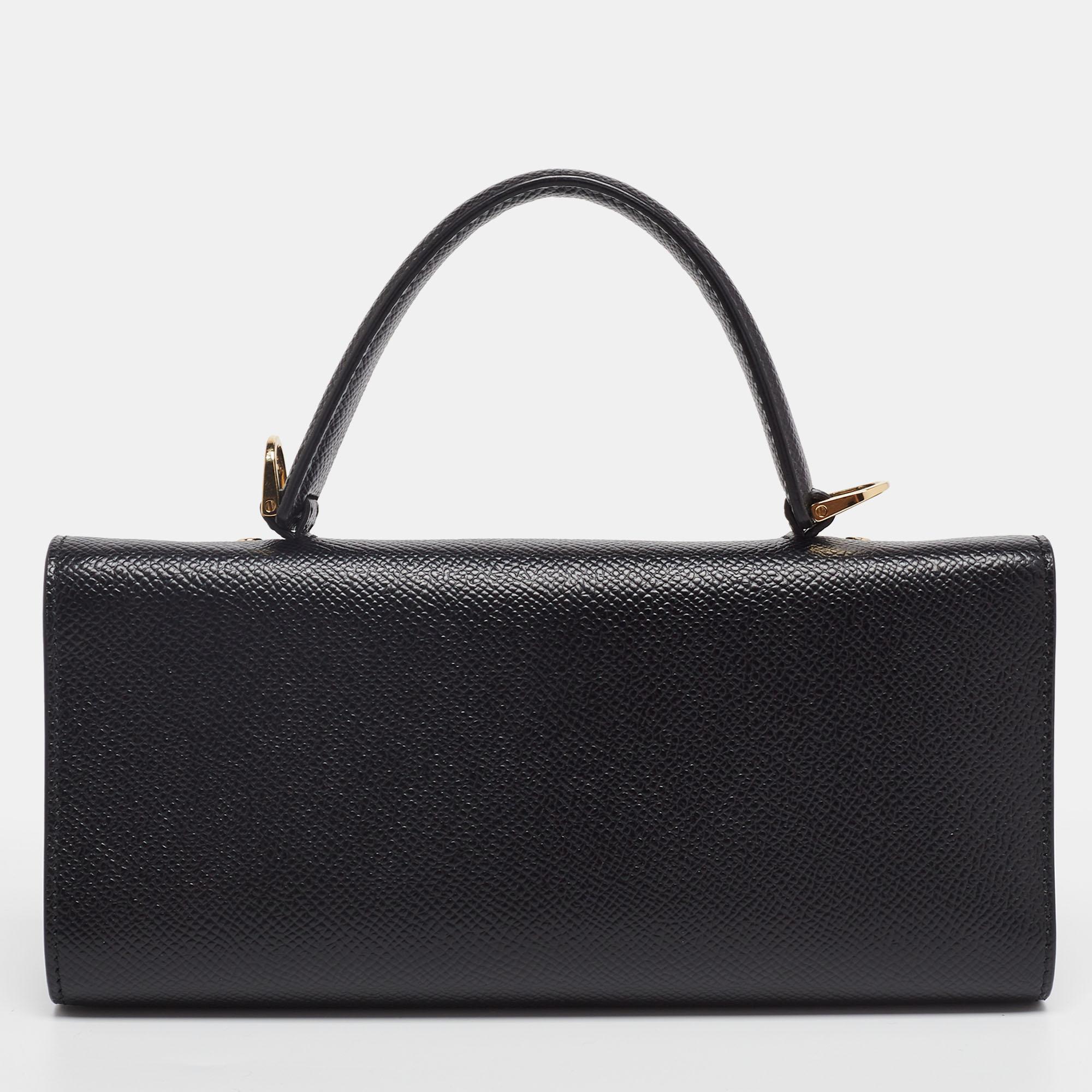 This Salvatore Ferragamo clutch bag is crafted from black leather and is highlighted by the Vara bow on the front. It has a top handle and a shoulder strap with a flap closure that opens to a well-sized interior. A truly perfect evening accessory to