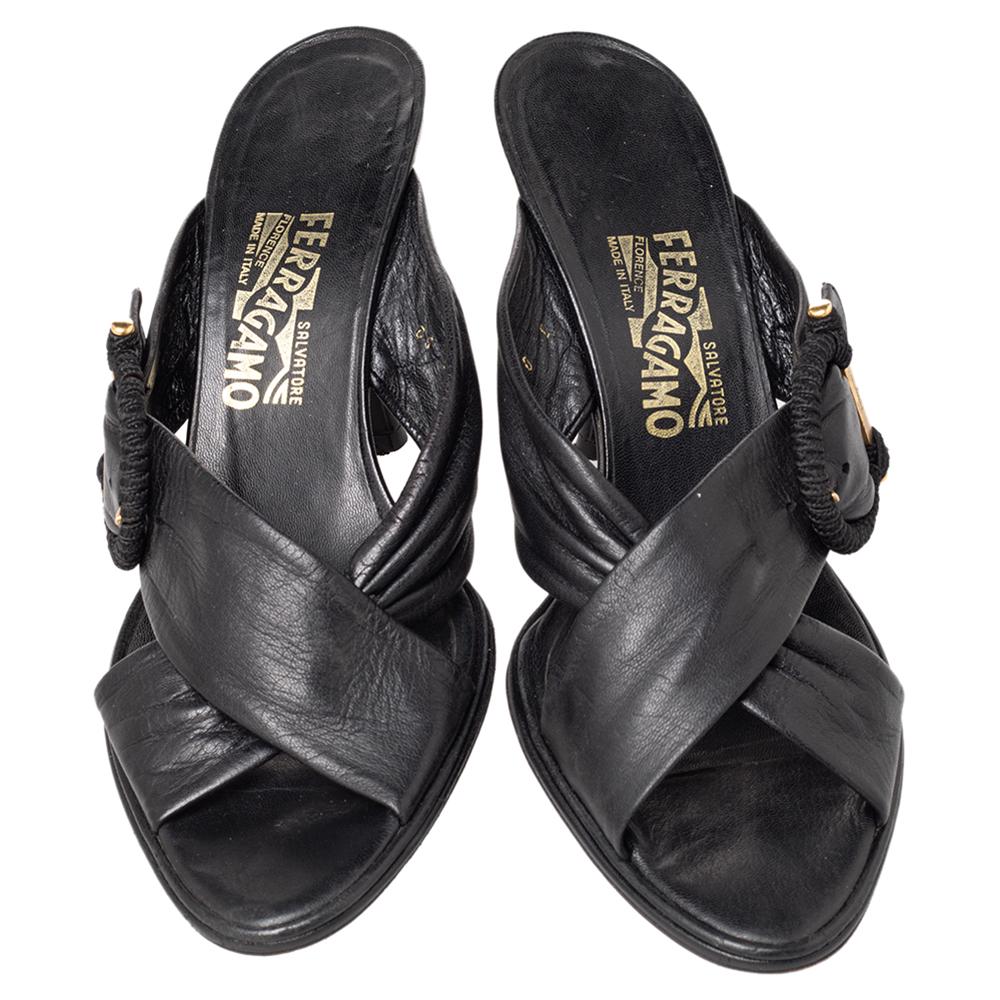 Look chic and fabulous with these Salvatore Ferragamo mules. Made from black patent leather, they feature stunning open toes, signature buckle detailing, and gold-tone hardware. Standing on 10 cm heels, the padded insoles are lined with leather and