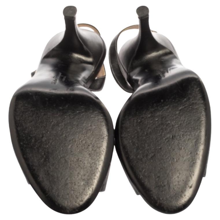 Endless compliments will come your way every time you wear these Salvatore Ferragamo sandals. The black sandals are crafted from leather and styled with open toes, a knot detailing on the neatly stitched vamps, and slingbacks with buckle fastenings.