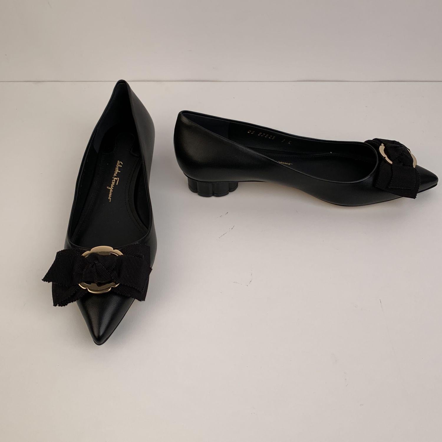 Classic Salvatore Ferragamo 'Talla 20' ballet flats. Crafted in black nappa leather. They feature a pointed toe, slip on design and a gros-grain bow on the toes. Gold metal accents. Covered flower-shaped block heels. Leather sole. Heels Height: 0.75