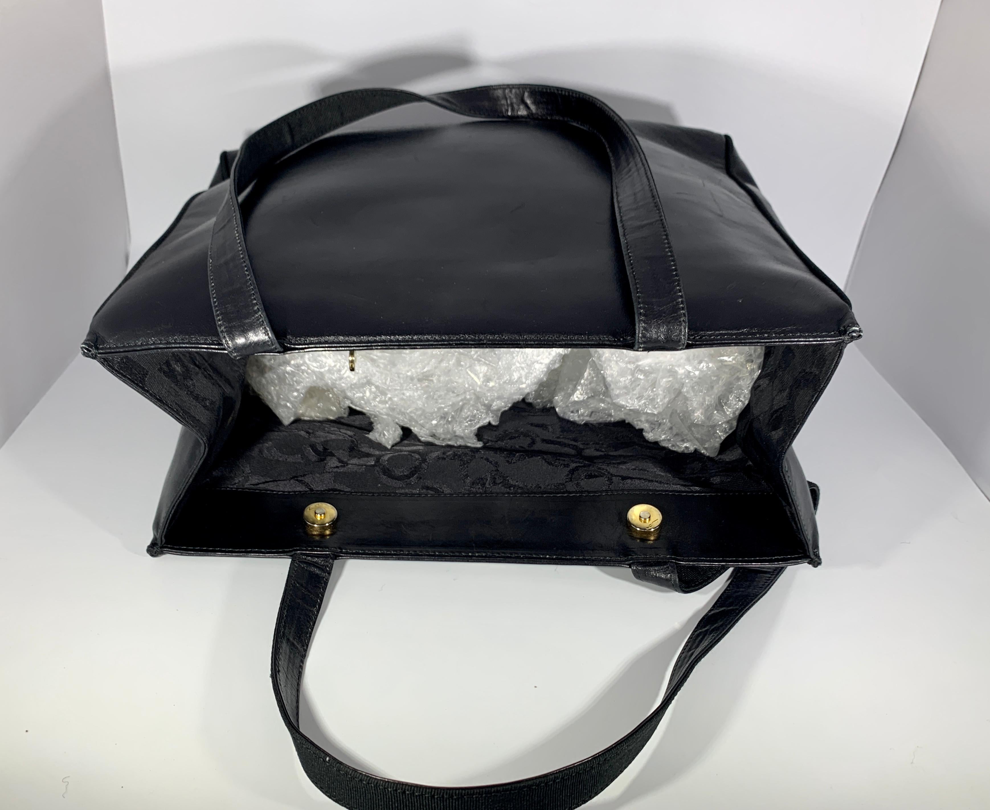 Ferragamo Black smooth leather tote with  Two snap  button closure on the top. Opens in to a very spacious  and a large zippered pocket. i
 Perfect for your laptop, books, and travel.
 Made in Italy
AQ 212530               
 SIZE 13