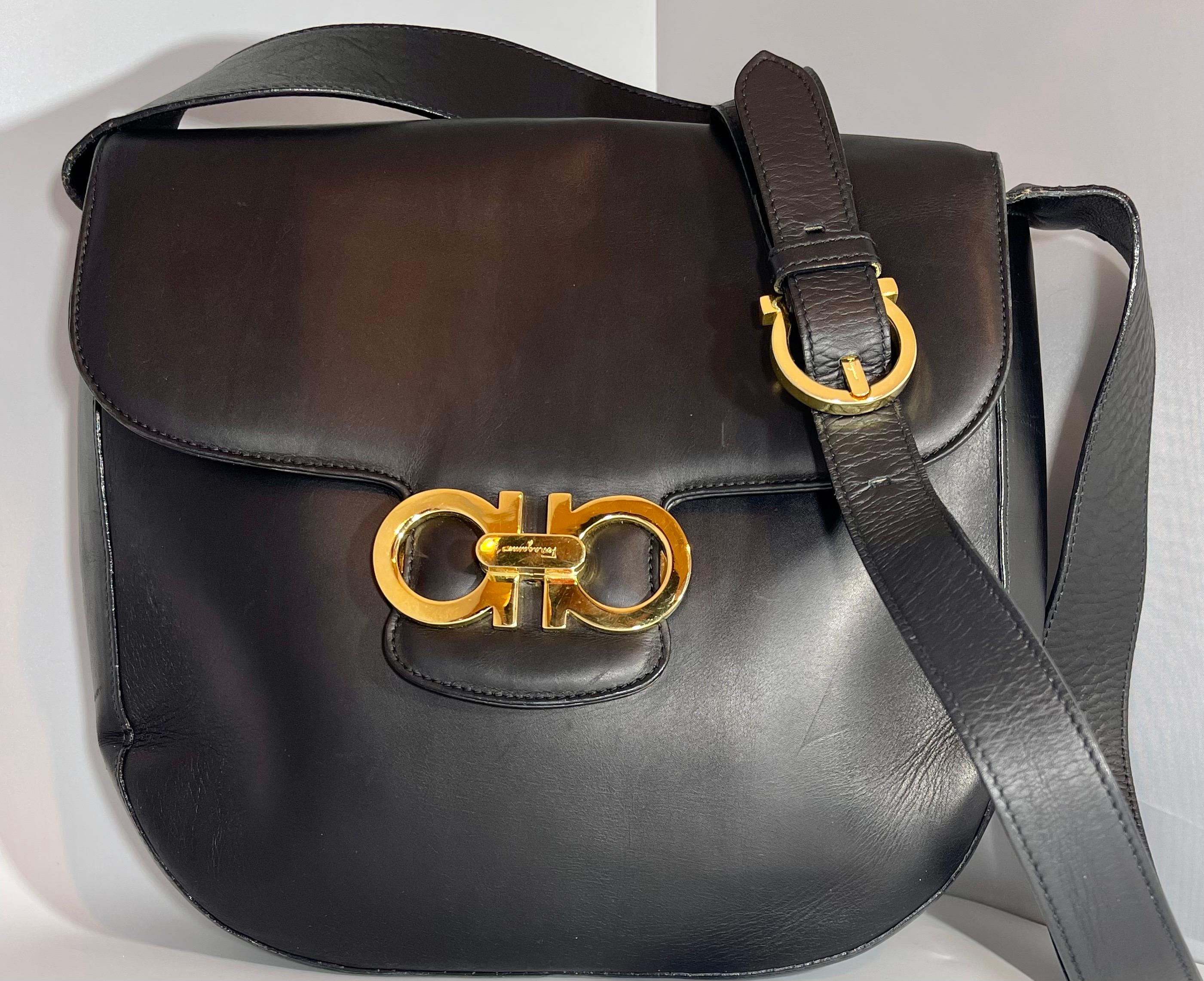 Salvatore Ferragamo Black  Leather Tote / Shoulder Bag  with Gold Hardware
Ferragamo Black smooth leather tote with  gold front clutch
Opens in to a very spacious   one Compartment and  and a large zippered pocket. 
It also has a key ring hanging