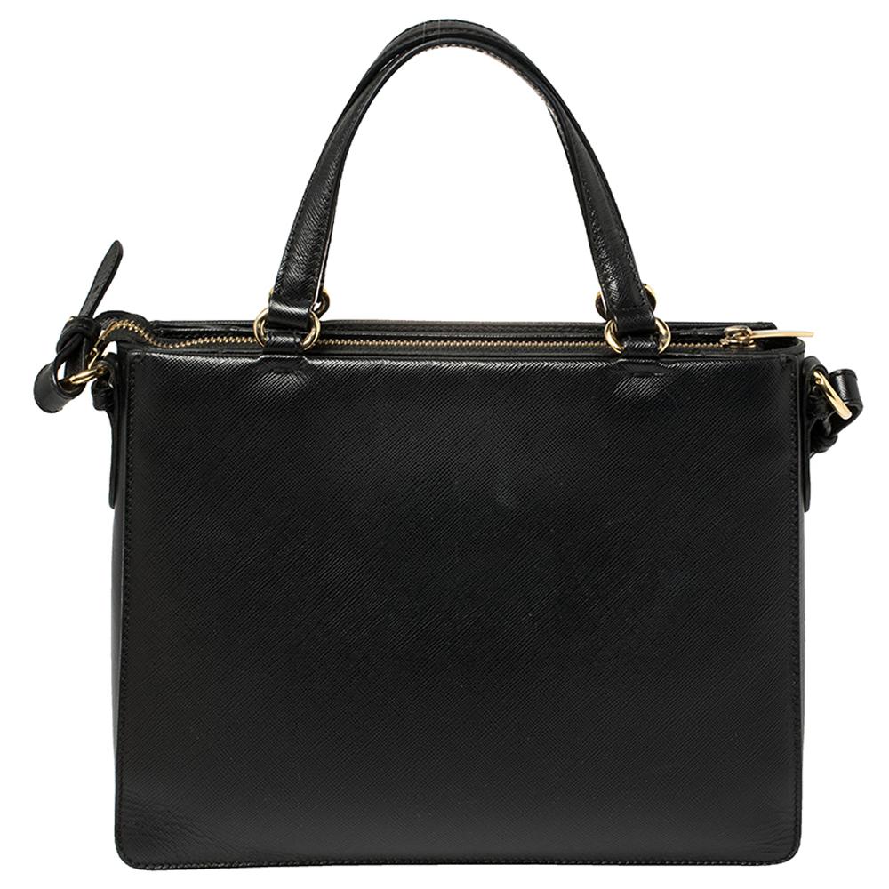 Diese strukturierte Salvatore Ferragamo Tracy Tasche ist ein Stück:: das die meisten Ihrer Outfits sehr gut begleiten kann. Sie ist aus schwarzem Leder gefertigt und mit der kultigen Vra-Schleife:: einem geräumigen Innenraum und zwei Griffen