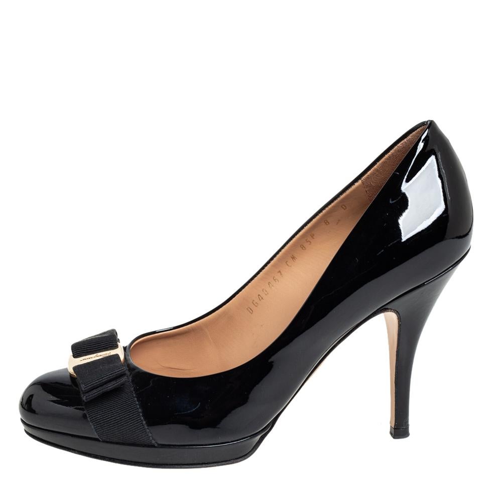 The iconic Vara bow decorates the vamps of these timeless Salvatore Ferragamo pumps. Created in a black shade from glossy patent leather and styled with almond toes and 11 cm heels, these pumps offer comfort with their leather-lined insoles. They