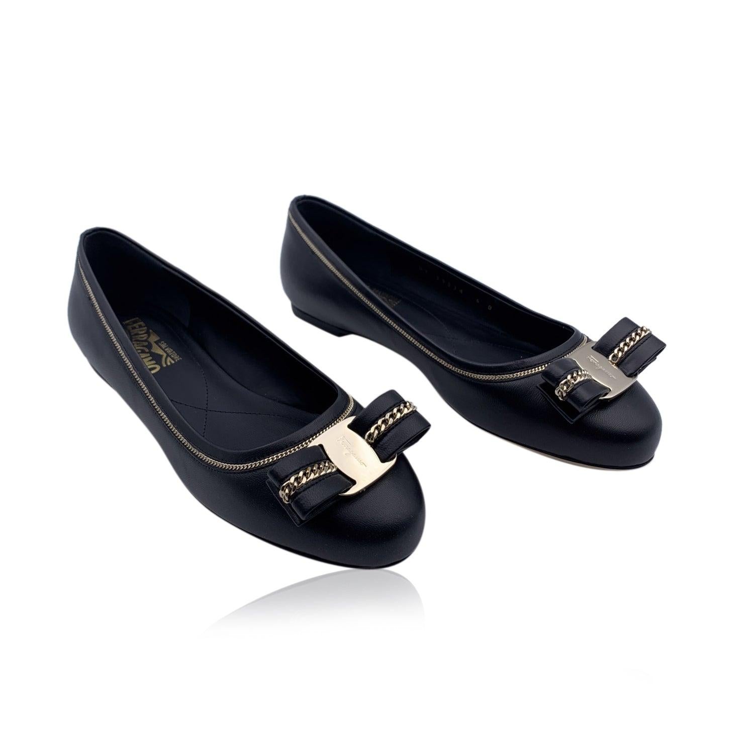 Sophisticated Salvatore Ferragamo 'Varina Lux' Ballet Flats. Crafted in black leather with gold metal chain detailing on borders. They feature a round toe, Vara-bow with chain on the toes. Leather sole. Made in Italy. Size: US 5.5C- EU 36C (The size