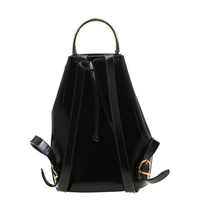 To accompany all your casual outings in the most fashionable way, Salvatore Ferragamo brings you this backpack that boasts of fabulous style. The patent leather bag has a drawstring to secure the canvas interior and is held by a top handle and two