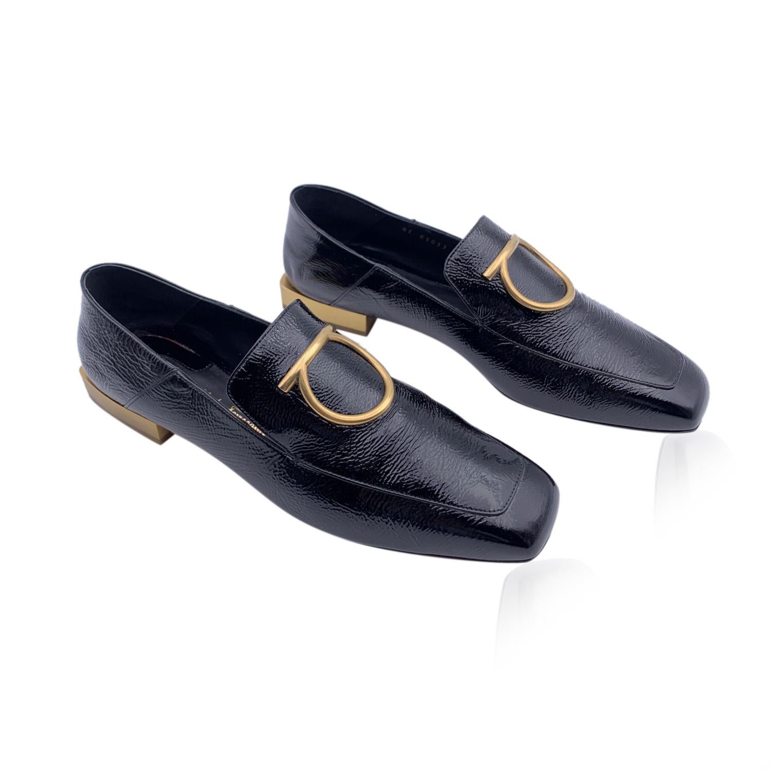 Beautiful Salvatore Ferragamo 'Lana' Moccassins Loafers Shoes. Crafted in black patent leather They feature a big gold metal Gancino detailing, a square toe and slip-on design. Leather sole with gold metal block heels. Heels height: 1cm. Made in
