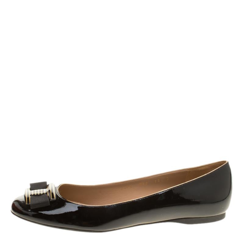 Nothing like a pretty pair of flats to be in high comfort and style! Crafted from patent leather in a shade of black, this gorgeous Ferragamo pair features leather-lined insoles housing the brand's iconic label and bows with striped metal detailing