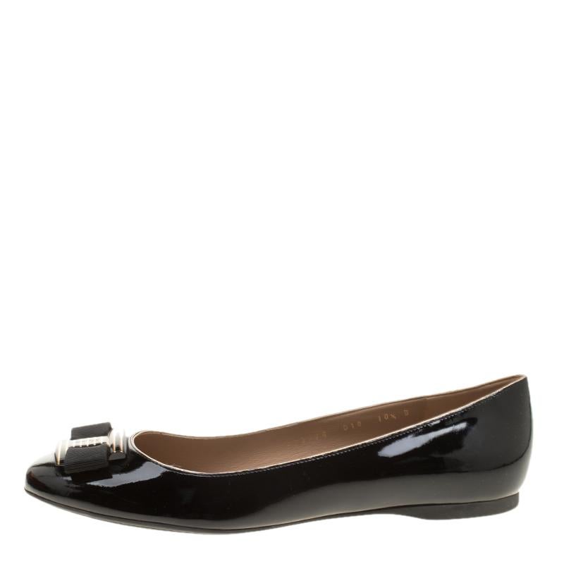 Nothing like a pretty pair of flats to be in high comfort and style! Crafted from patent leather in a shade of black, this gorgeous Ferragamo pair features leather-lined insoles housing the brand's iconic label and bows with striped metal detailing