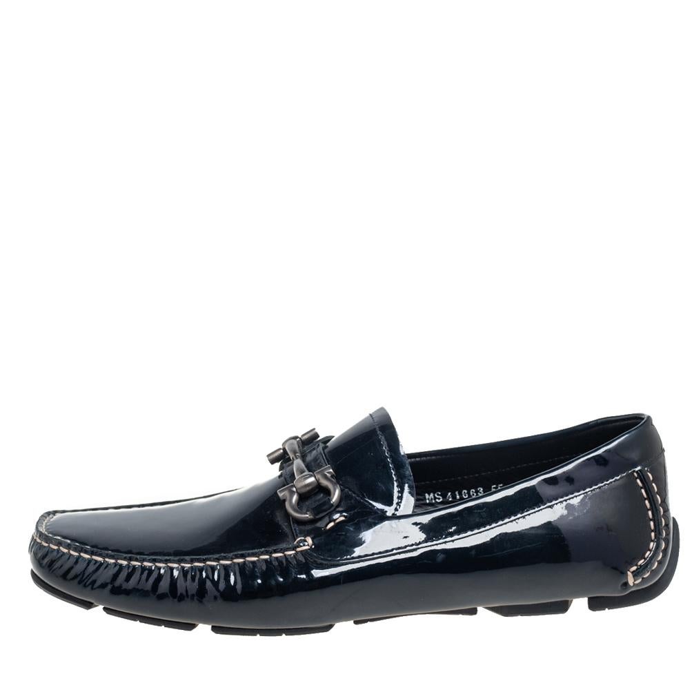 These Parigi loafers from Salvatore Ferragamo grant your feet with never-ending style and luxury. These loafers feature black patent leather on the exterior, with a silver-toned Gancini motif perched on the vamps. Experience maximum comfort as you