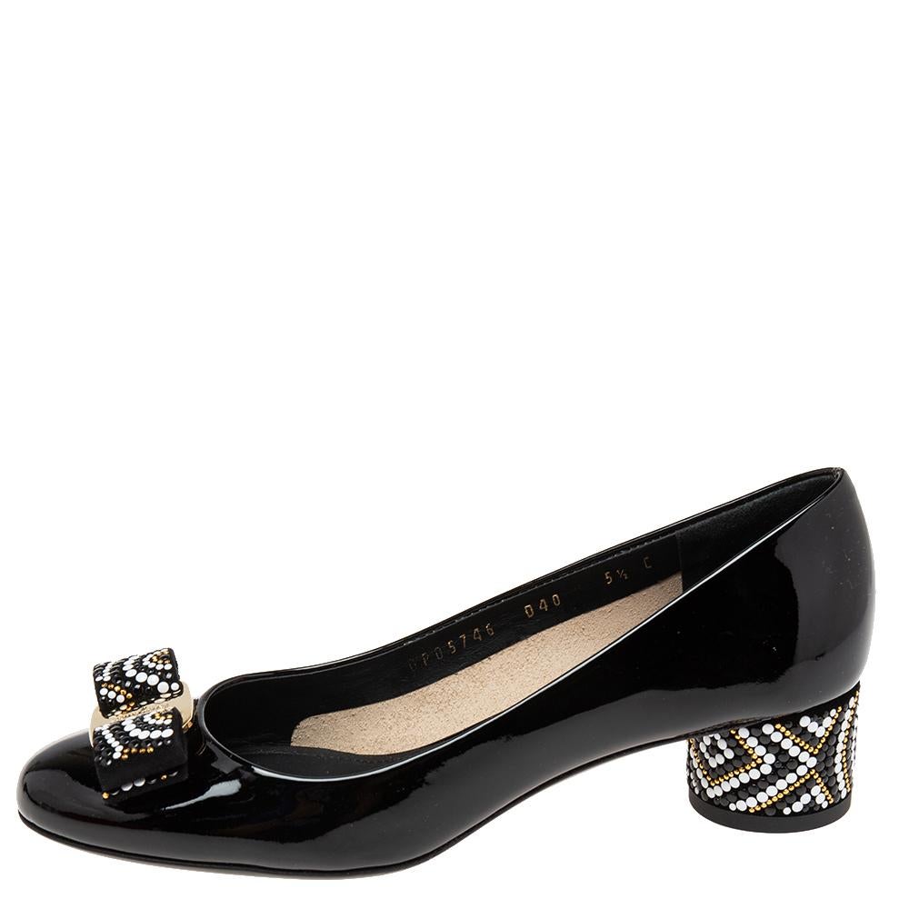 These Vara Bow pumps from the House of Salvatore Ferragamo will make you look classy and chic. They are made from black patent leather, with a mosaic-detailed Vara Bow placed on the rounded toes. They have gold-tone hardware and block heels. These