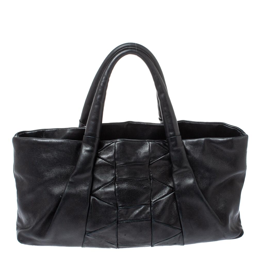 Stunning in appeal and high on style, this Ferragamo tote has been crafted from black leather and designed minimally with dual top handles. It features a pleated exterior and the fabric-lined interior is well-sized to hold all your essentials. The