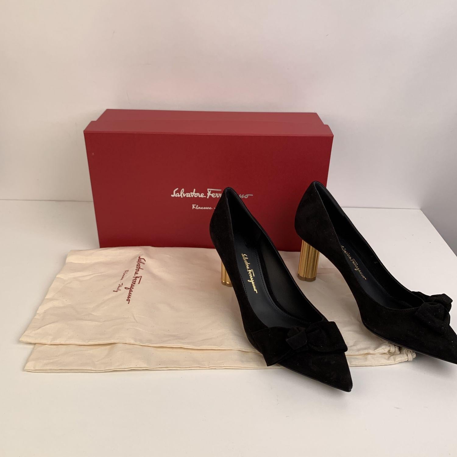 Classic Salvatore Ferragamo 'Garlate' closed toe pumps. Crafted in black suede. They feature a pointed toe, slip on design and gold metal coloumn flower-shaped covered heel. bow detailing on the toes. Leather insole and outsole. Heels Height: 2.75