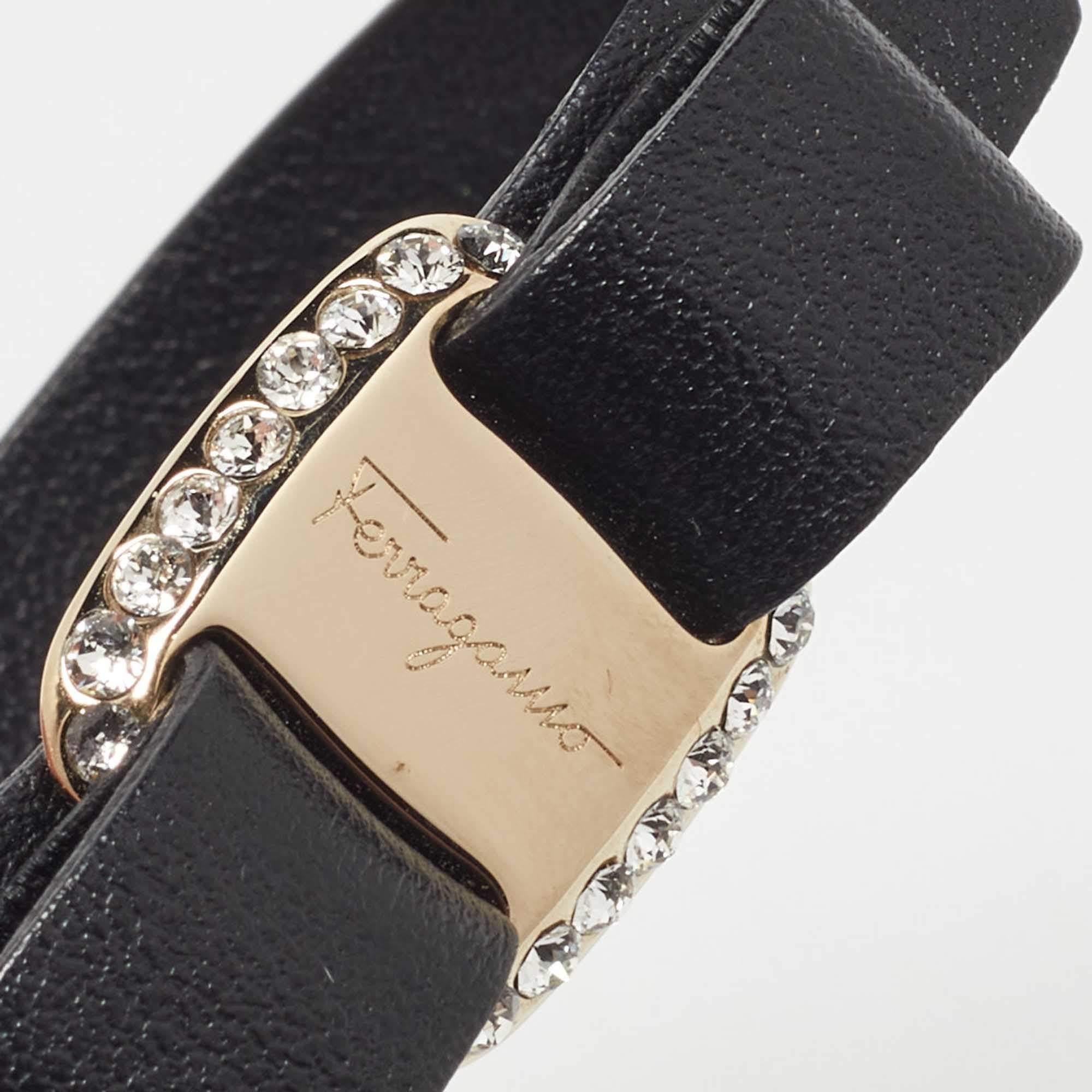 The Salvatore Ferragamo bracelet is an elegant accessory. Crafted from black leather, it features a signature Vara bow embellishment in gold tone metal. This bracelet combines sophistication with a touch of luxury, making it a timeless addition to