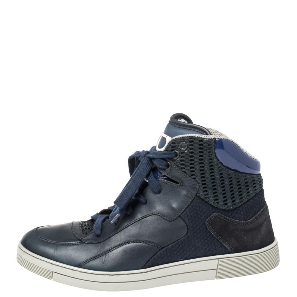 These high-top sneakers from Salvatore Ferragamo are a perfect blend of comfort and style! They have been crafted from blue leather and mesh and styled with round toes, lace-ups on the vamps, and the signature Gancini motif on the tongues. They are