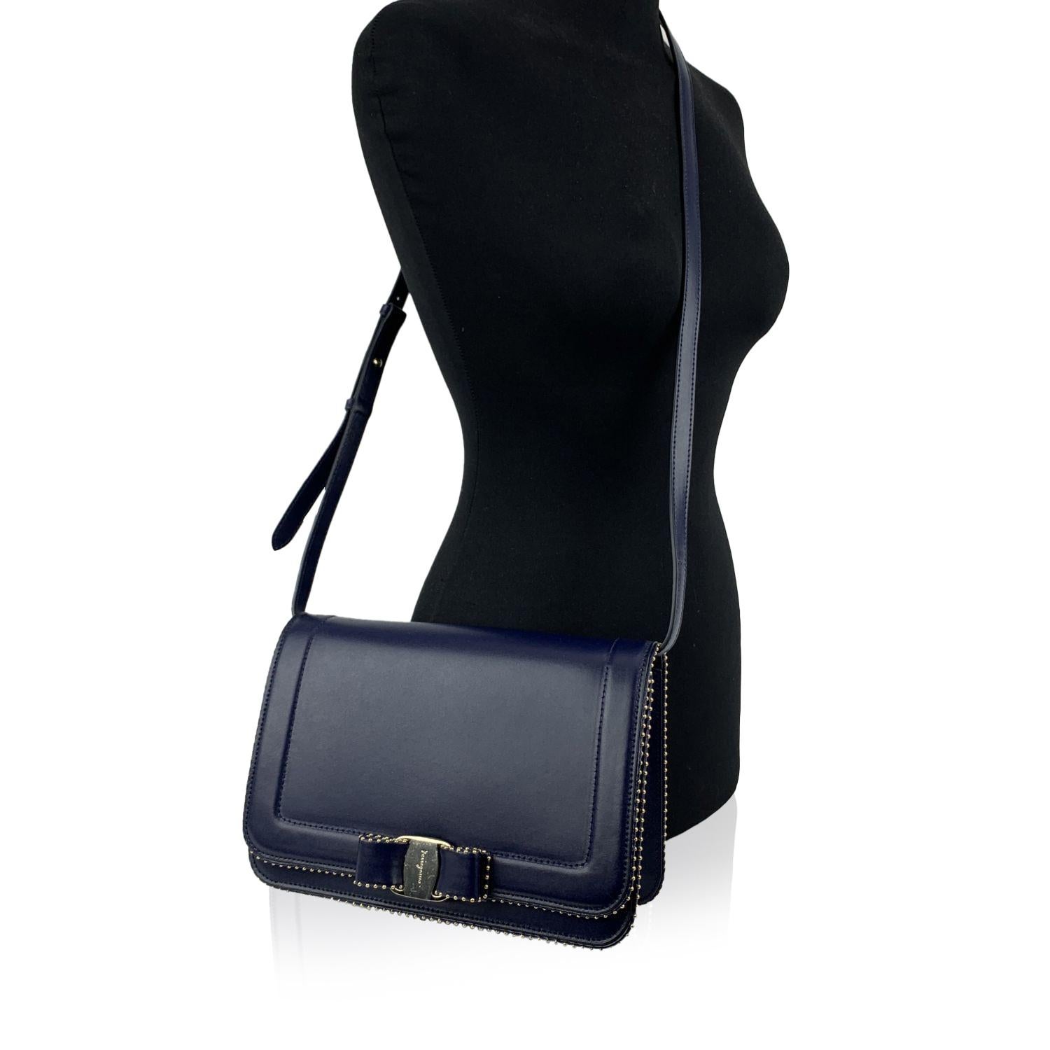 Beautiful 'Vara RW O' shoulder bag by Salvatore Ferragamo. Made of blue calf leather. It features a flap closure with iconic Vara Bow detailing on the front and gold metal micro-studs detailing around the edges of the bag. Adjustable shoulder strap.