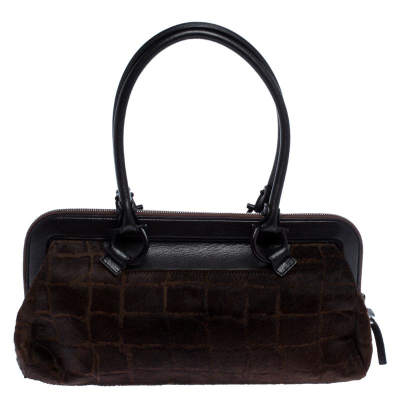 Flaunt this bag from Salvatore Ferragamo and see how the compliments come pouring in. Crafted from calfhair and leather, it comes in black and brown hues. This satchel is held by dual handles, an exterior pocket, zip closure that opens to a
