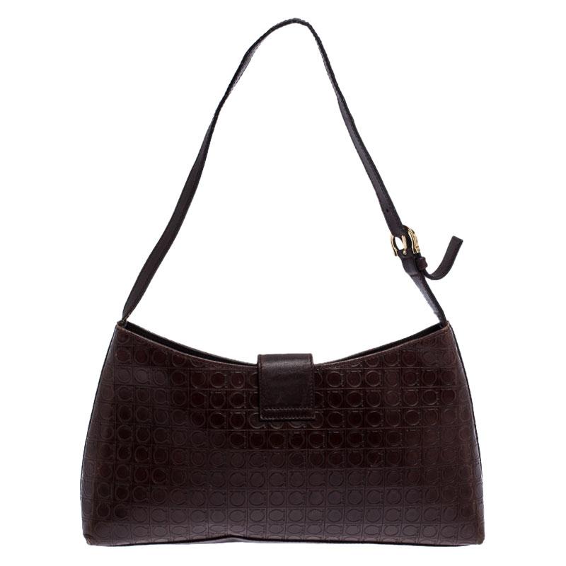 This elegant handbag by Salvatore Ferragamo will make you stand apart from the crowd. Crafted from leather it flaunts the Gancini logo embossed on the exterior. It features a single handle and the Gancini logo on the flap opens to a nylon lined