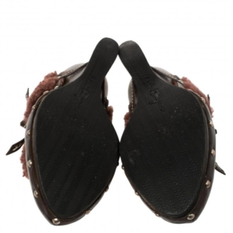 Comfort and style come together and bring forth these fabulous Salvatore Ferragamo mules that deserve a very special place in your wardrobe! The brown clogs are crafted from leather and feature a faux fur trim on the vamps, studded midsoles, and