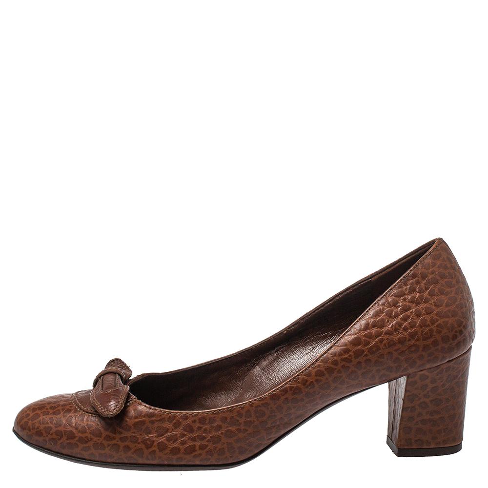 With a classic and elegant style and a timeless charm, this pair of Salvatore Ferragamo pumps are versatile. Crafted in brown leather, this pair features dainty bows on the uppers and is raised on block heels.