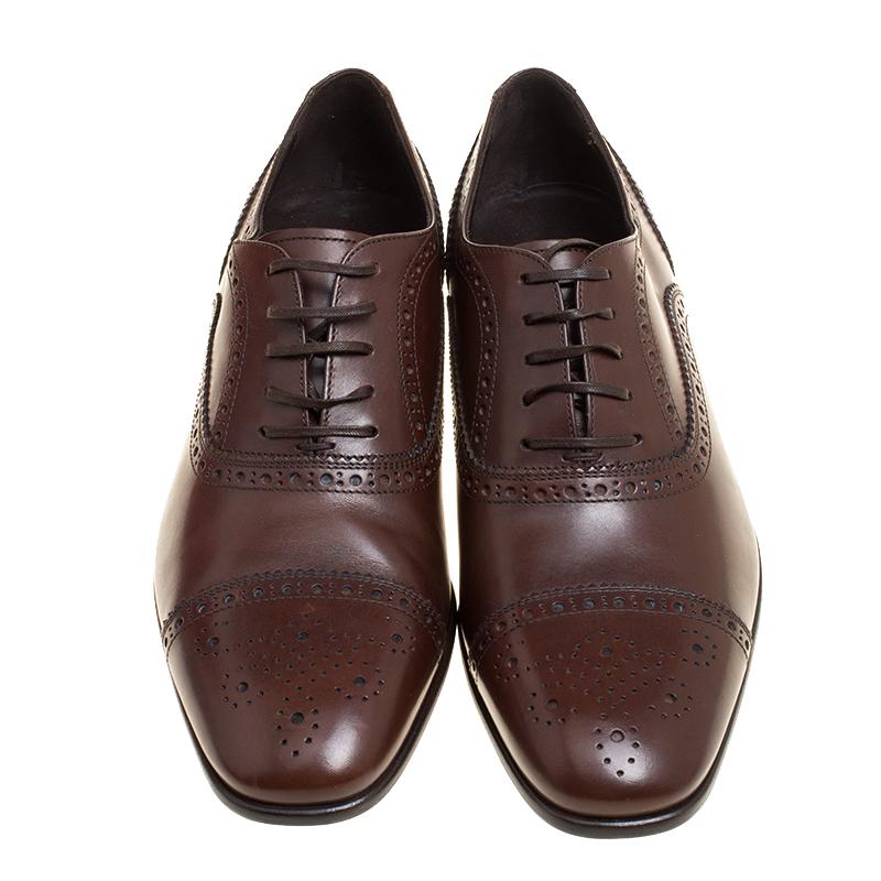 These oxfords from Salvatore Ferrafgamo are sure to make you look suave, smart and very chic. The brown shoes are crafted from leather and feature a brogue detailing They are also equipped with a leather lined insole and simple tie-ups. With tough