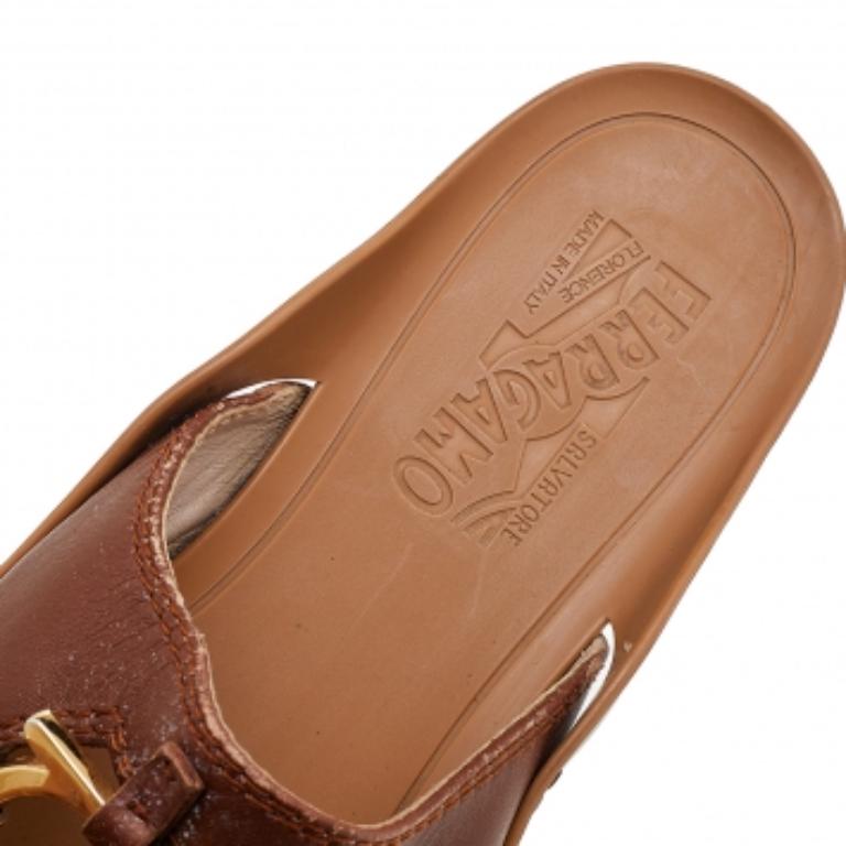 Schlüpfen Sie in diese braunen Salvatore Ferragamo Zehenstegsandalen für einen lässigen Tag im Freien. Sie sind aus Leder im Zehensteg-Stil gefertigt und verfügen über ein goldfarbenes Gancini-Logo auf dem Obermaterial und eine Gummisohle mit dem