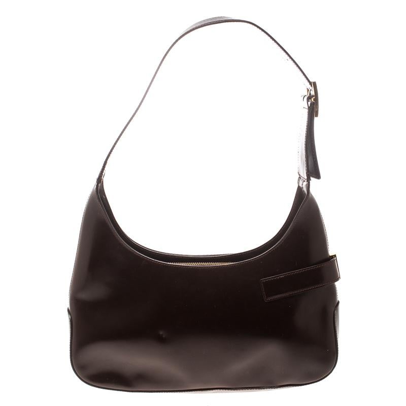 Finely crafted from leather, and shining with beauty is this beautiful hobo by Salvatore Ferragamo. It comes in a great shape with Gancio detailing and a fabric compartment to store your essentials. Complete with a single handle, you truly deserve