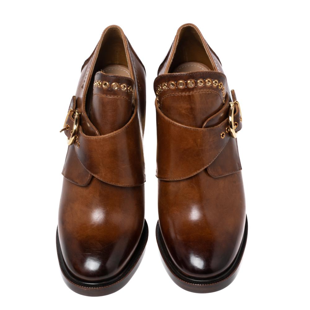A pair of designer boots by Salvatore Ferragamo to light your steps in a fashionable manner. The brown boots are finely crafted from leather and designed with covered toes, eyelets, high heels, and a front buckle strap.

Includes: Original Box, Info