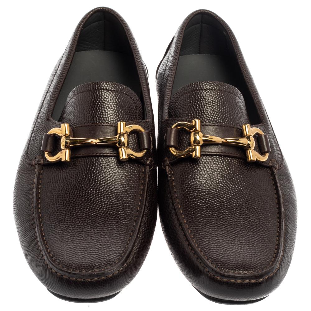These brown loafers by Salvatore Ferragamo are a result of skillful craftsmanship and luxury designing. They have been crafted from quality leather in Italy and designed with beauty using neat stitching and the Gancini logo on the uppers. The