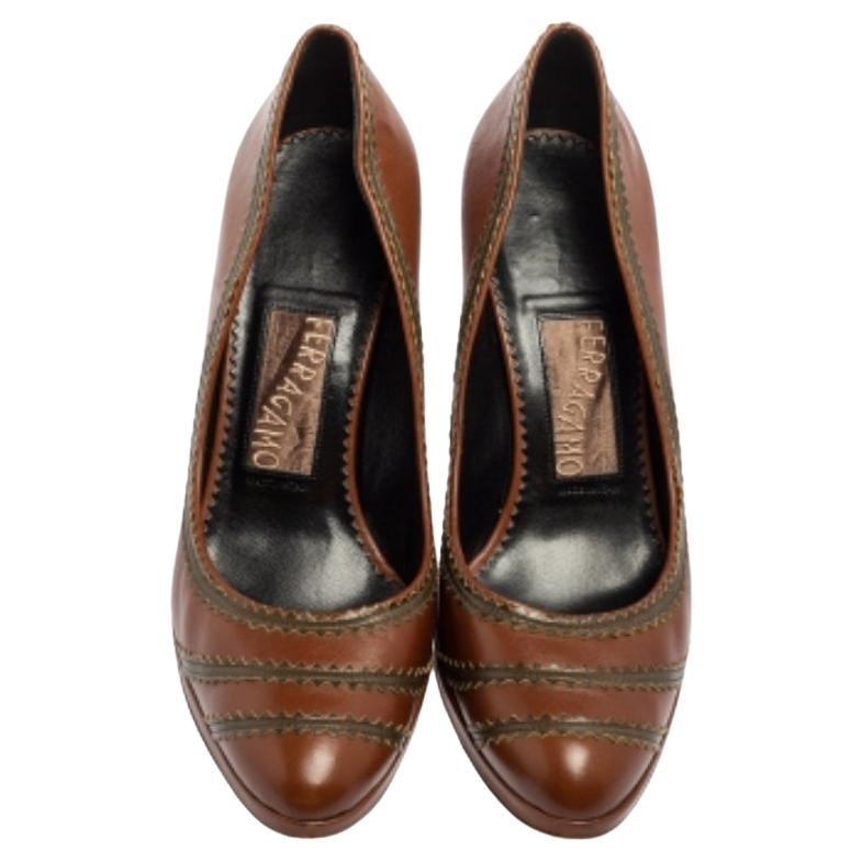 Aggiungi un tocco di lusso al tuo abbigliamento indossando queste décolleté della Maison Salvatore Ferragamo. Sono realizzate in pelle marrone. Presentano tacchi robusti, plateau e uno stile slip-on. Queste décolleté sono davvero una creazione di