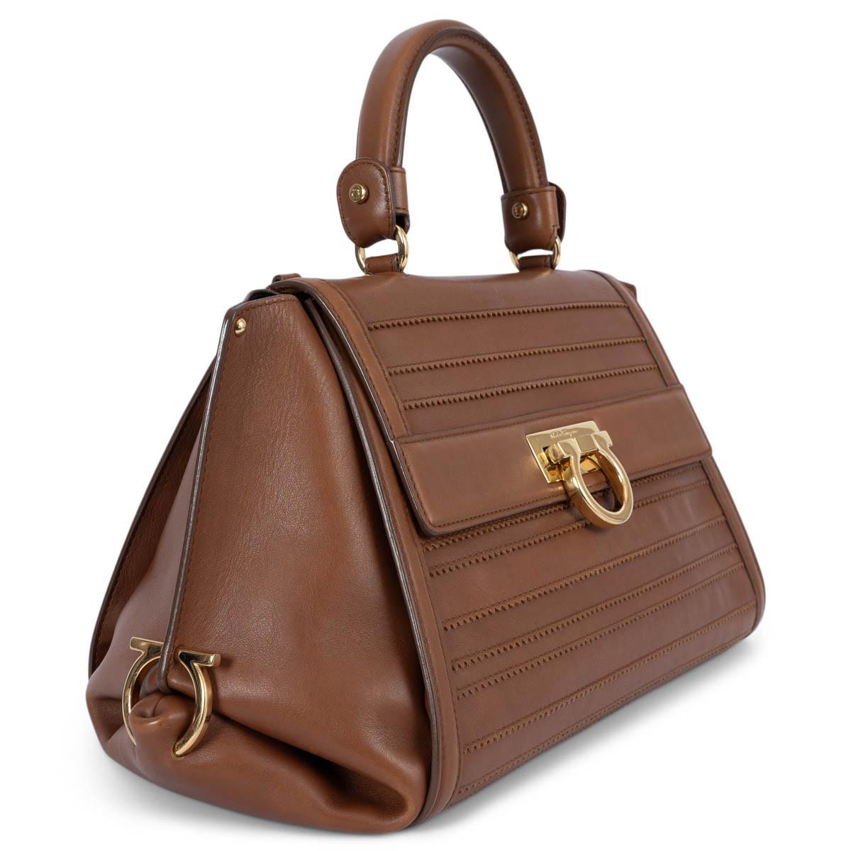 100% authentic Salvatore Ferragamo Sofia shoulder bag in brown leather featuring gold-tone hardware. Opens with logo flap fastener and is lined in lack and yellow calfskin with three open pockets. The design features an adjustable and removable