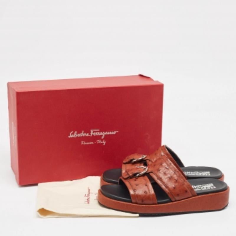 Diese flachen Sandalen aus dem Hause Salvatore Ferragamo sind hier, um Ihren Füßen unendlichen Stil, Luxus und Komfort zu bieten. Sie sind aus braunem Straußenleder gefertigt. Sie haben silberfarbene Beschläge und sind zum Hineinschlüpfen geeignet.