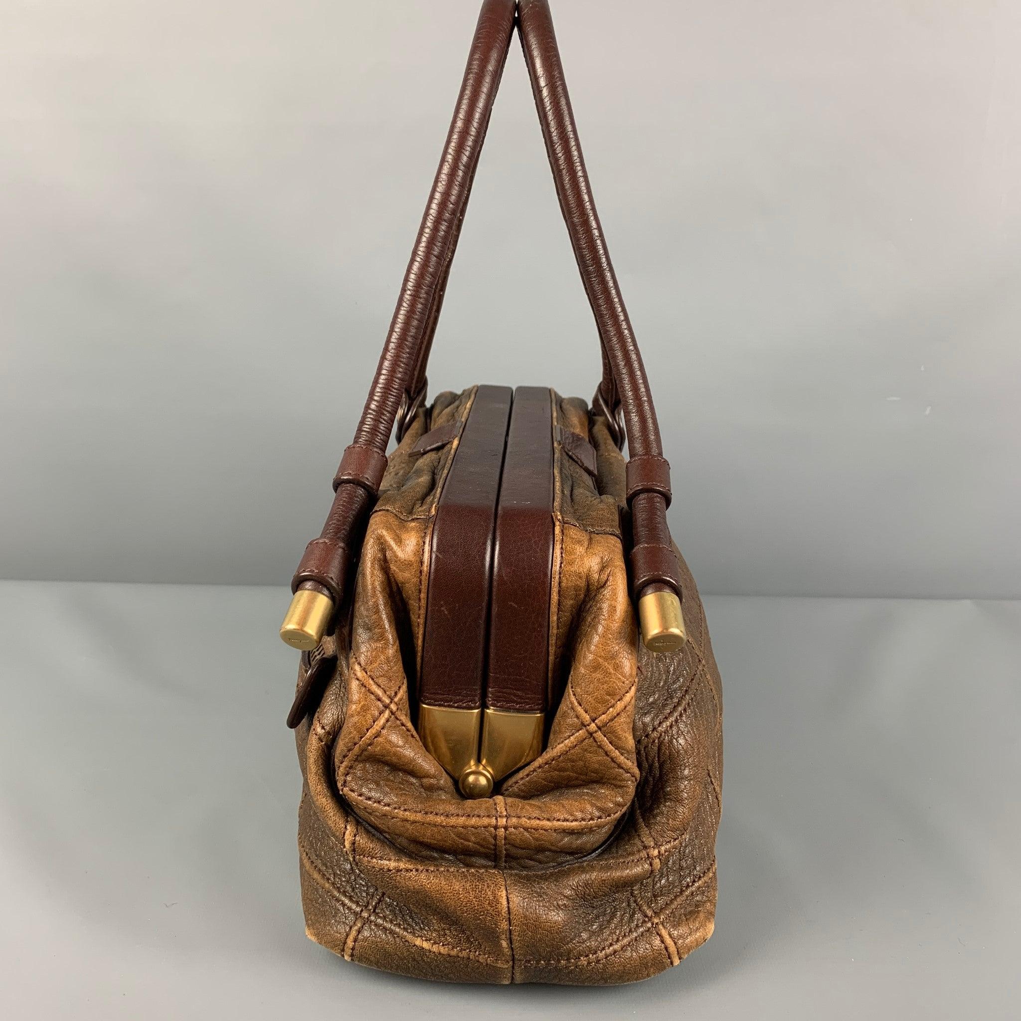SALVATORE FERRAGAMO handbag comes in a brown quilted leather featuring top handles, gold tone hardware, fringe charm detail, inner pocket, and a magnetic closure. Made in Italy.
Good
Pre-Owned Condition. Moderate wear. As-Is.  

Marked:   FG216831