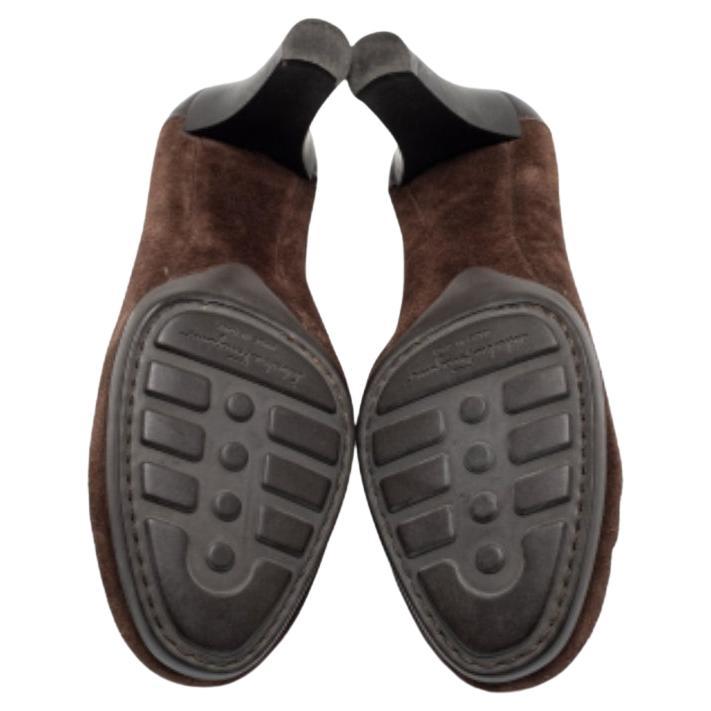 De la casa Salvatore Ferragamo llegan estos magníficos mocasines que realzarán tu atuendo. Están confeccionados en ante marrón y piel, con abalorios de borla colocados en la parte delantera. Tienen forma deslizante, tacón de 7 cm y herrajes