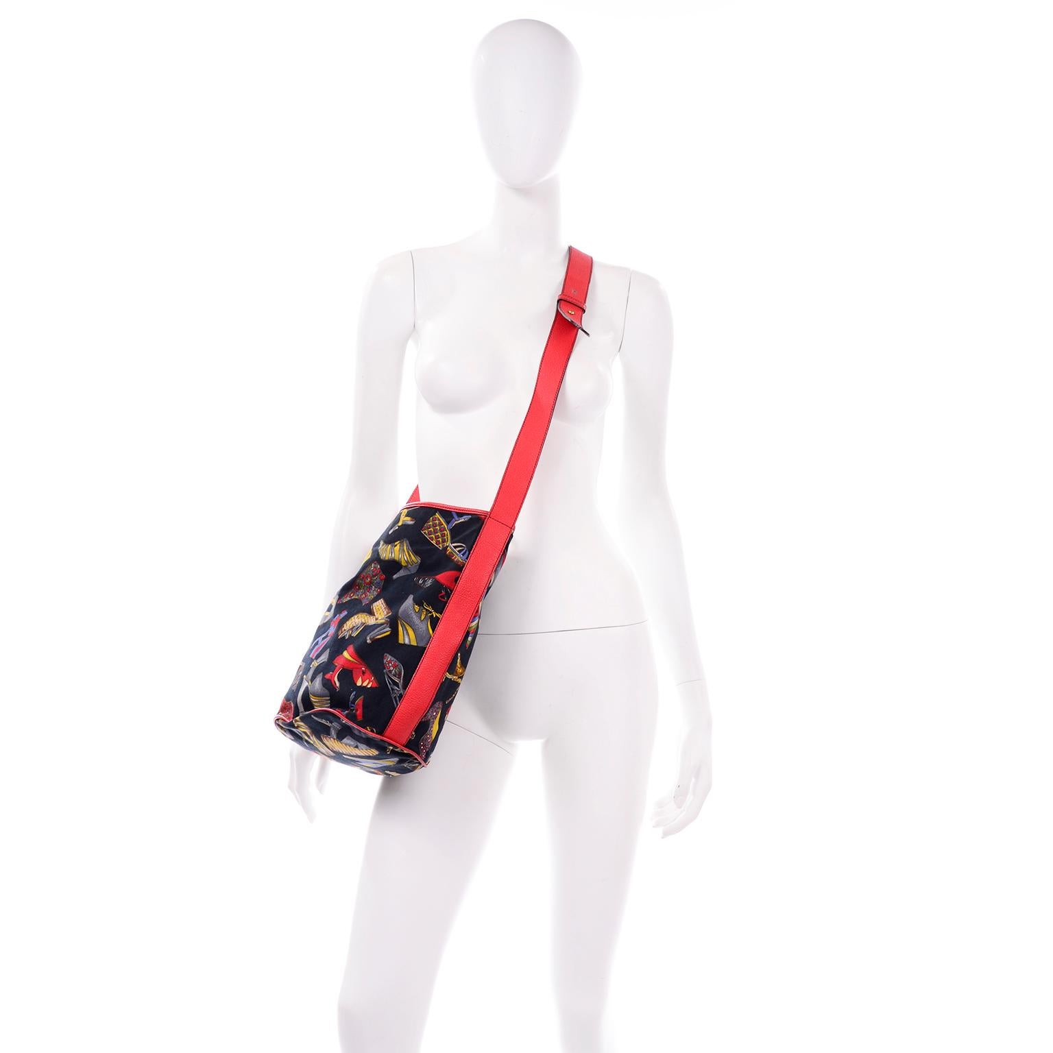 This is such a great vintage Ferragamo novelty shoe print canvas bucket bag with red/orange leather trim and crossbody strap. It has a large gold buckle on top, with two open pockets and one large zipper pocket in the center. We love the colorful