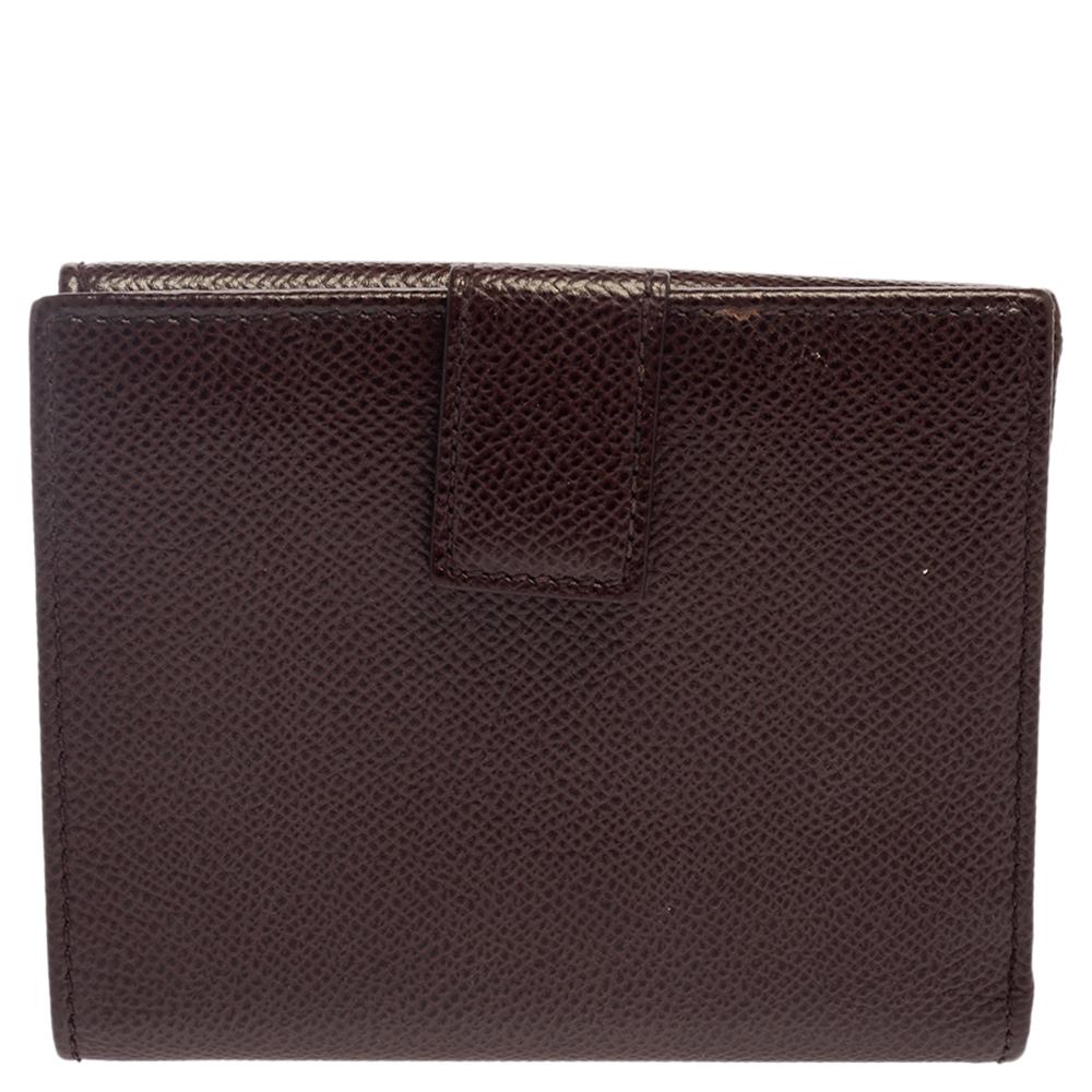 This Ferragamo wallet is sure to be your compact comrade and ideal for your daily essentials. It is beautifully designed featuring the signature Gancini clip fastening on the front flap, making it instantly recognizable. There is a flap on each side