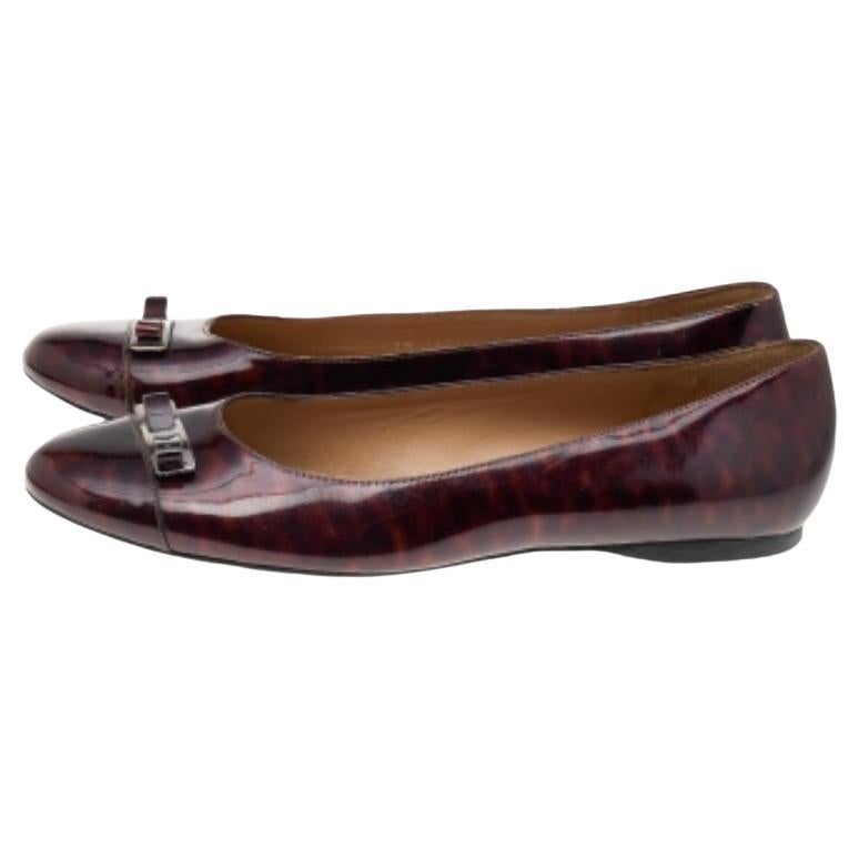 Ces chaussures plates Vara Bow de la maison Salvatore Ferragamo vous donneront une allure classe et chic. Elles sont réalisées en cuir verni bordeaux sur l'extérieur, avec un nœud Vara signature placé sur les orteils. Ces chaussures plates