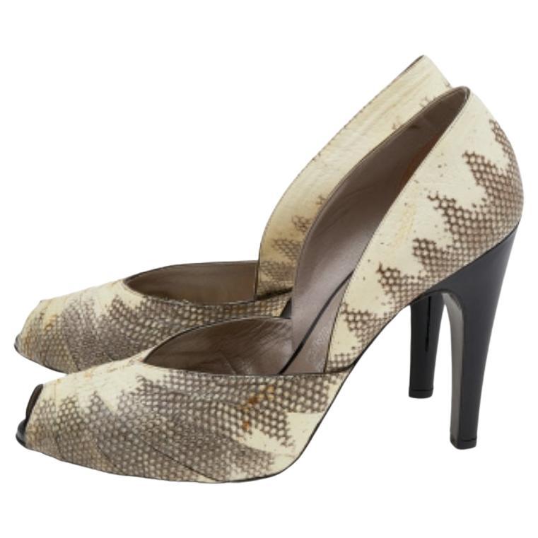 Diese Salvatore Ferragamo Pumps aus auffälligem und luxuriösem Karung- und Lackleder sind ein echter Hingucker auf Partys und besonderen Anlässen. Diese Schuhe mit Peep-Toe-Vorderseite haben eine cremefarbene und schwarze Farbkombination, ein