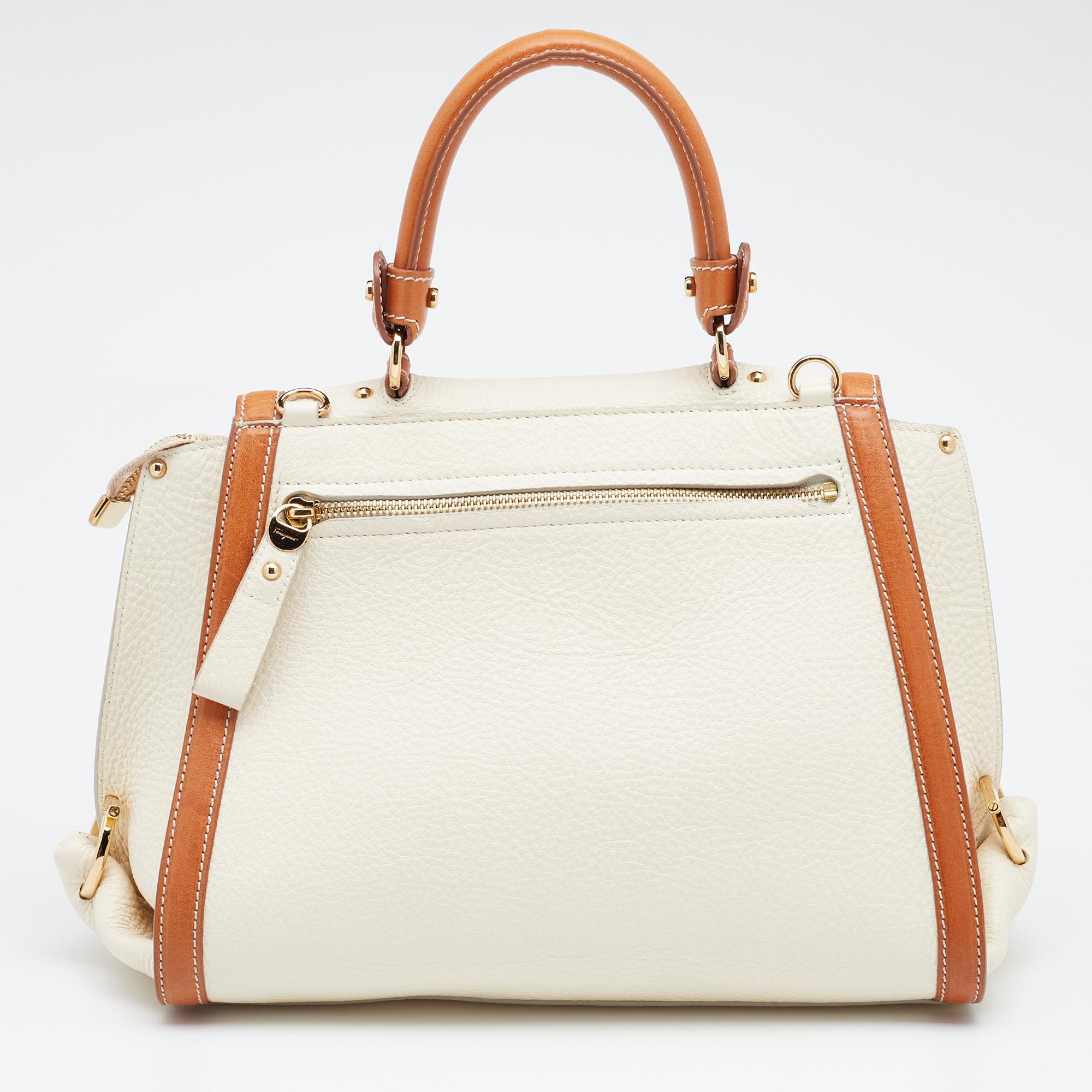 A beautifully made bag that can be used with both day and evening looks, this Salvatore Ferragamo Sofia bag will never fail to impress you. Crafted in leather, it features a top handle for your convenience. With gold-tone hardware details and a