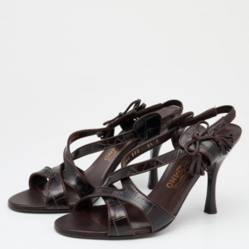 Die Riemchensilhouette dieser Salvatore Ferragamo Sandalen wird durch Quasten und silberfarbene Beschläge ansprechend gestaltet. Sie sind aus Leder mit Kroko-Prägung gefertigt, haben einen Slingback-Verschluss, eine offene Spitze und einen 10 cm