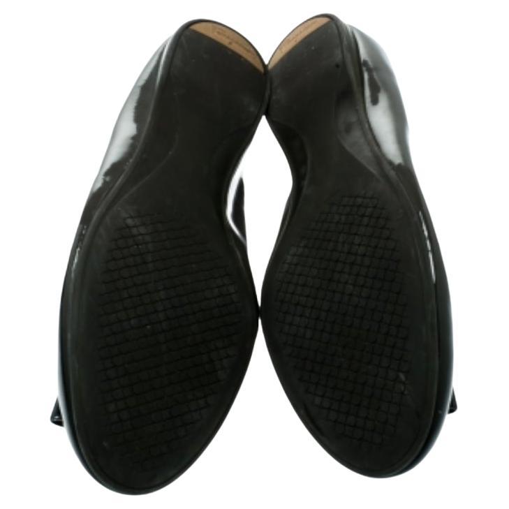 Queste ballerine di Salvatore Ferragamo ti stupiranno per il loro stile e il loro design! Le ballerine grigio scuro sono realizzate in vernice e hanno la punta arrotondata. Sono caratterizzate dai caratteristici fiocchi sulla tomaia e sono dotate di